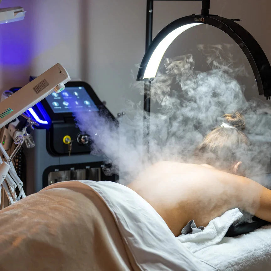 Person receiving a steam treatment in a clinical setting with medical equipment.