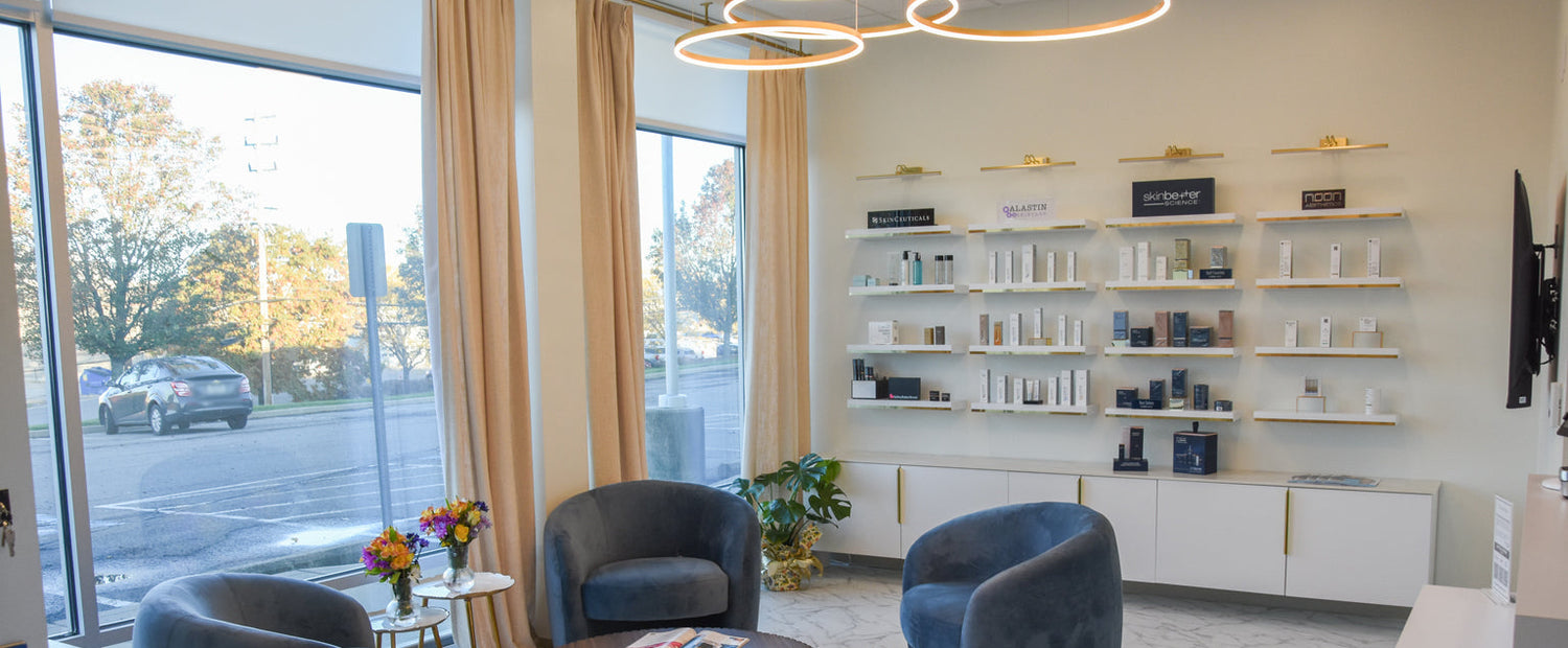 Modern waiting room with blue chairs, a coffee table, and shelves with decorative items.